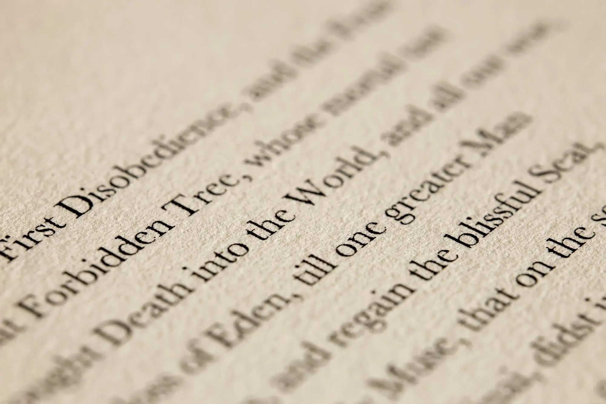 Close-up of the opening lines of Paradise Lost printed on cream paper.